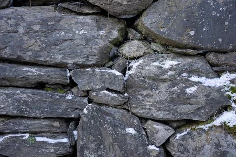 Snow covered stone wall in winter Stock Photos