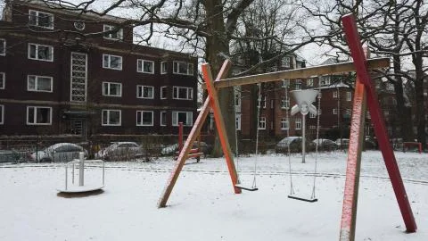 Snow covered Swing &amp; Carousel on a playground 库存照片