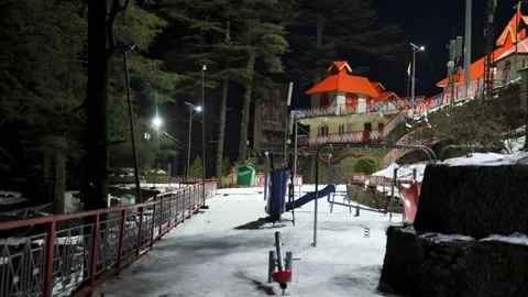 Snow covered temple complex with empty playground at night in hill station Stock Footage 328956386