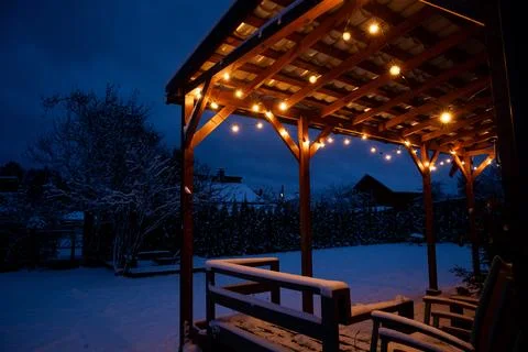 Snow Covered Terrace with LED String Lights and Wooden Pergola Stock Photos