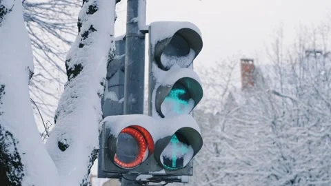 Snow covered traffic light operating in winter city street scene Stock Footage 325529072