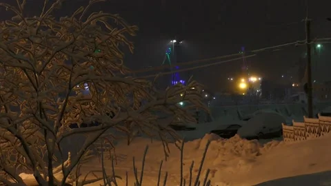 A snow-covered tree on the background of a working port crane. Stock Footage 154054276