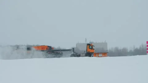 Snow-Covered Trucks makes clean of runway in an Airport winter Stock Footage 255121225