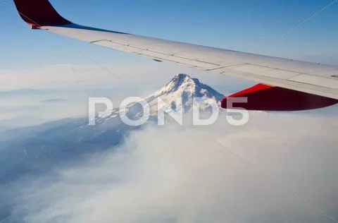 Snow covered volcano under aircraft wing Stock Photos