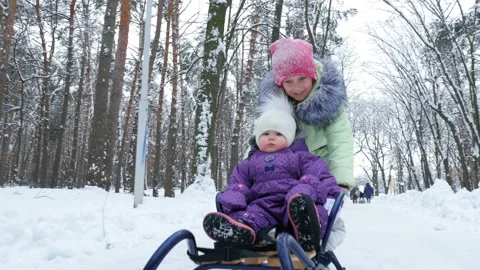 In the snow-covered winter forest, two girls, one year and seven years old, have Stock Footage 86152533