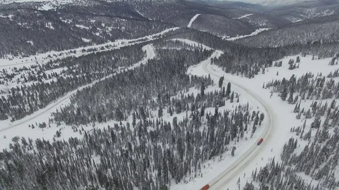 Snow-covered winter road in the mountains. Aerial View. Video stock 75048152