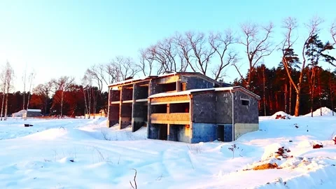 Snow covers the abandoned building in the forest during late afternoon light Vídeo Stock 328138705