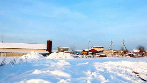 Snow covers buildings and fields in a rural area during winter Stock Footage 328245202