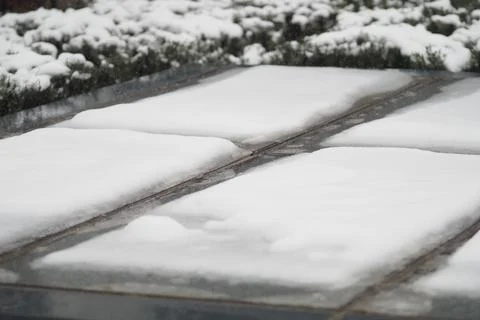 Snow covers the ground and paths in a winter scene Stock Photos