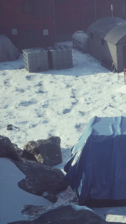 Snow covers the ground near structures in a remote area of winter Stock Footage 346758927