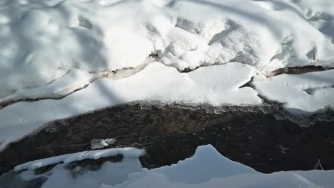 Snow covers the ground in a winter landscape with patches of exposed earth and 스톡 동영상 337101560
