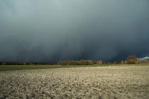 Snow dark front cloud and plowed field Stock Photos