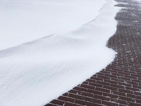 Snow drift with red brick wall in background. Foto stock