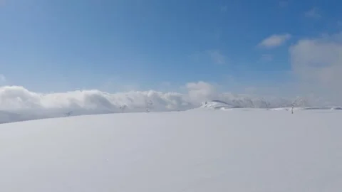 Snow drifting over bleak mountain top winter landscape Stock Footage 245059789
