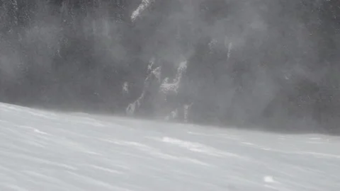 Snow drifting through the air because of heavy snowstorm on the mountain peak Stock Footage 155717613