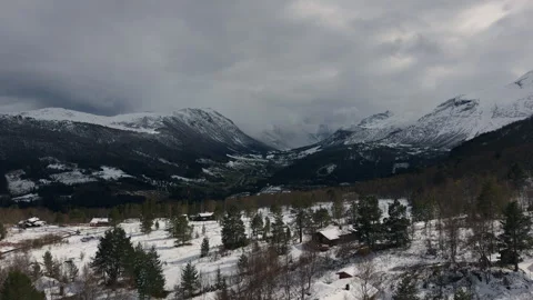 Snow-Dusted Forests and Cabins Amidst Dramatic Norwegian Mountains Stockbeeldmateriaal 334742470