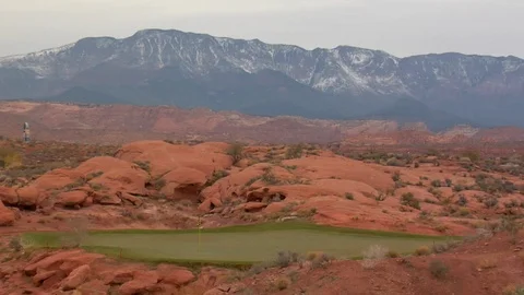 Snow dusted mountains behind desert sand, rocks and golf course Stock Footage 125344829