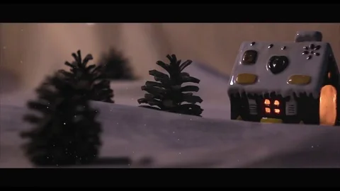 Snow fall on gingerbread house surrounded by fir-trees and snow drifts Stock-Footage 70062586