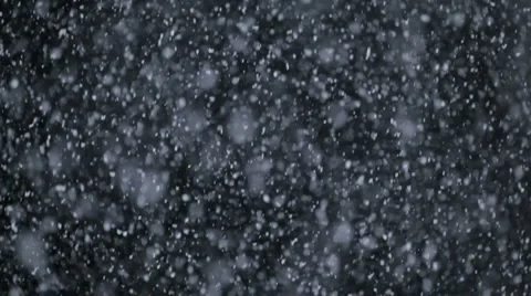 Snow falling against a black background Stock Footage 1084885