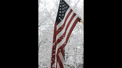 Snow falling on an American flag Stock Footage 34259473