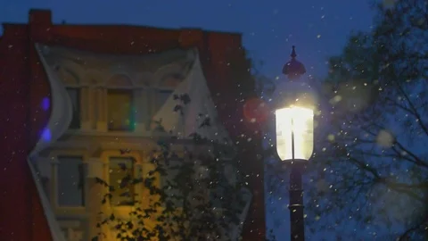 Snow falling around bright light lamp post in winter 02 Vídeo Stock 99066769