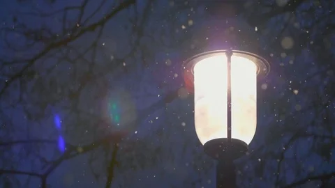 Snow falling around bright light lamp post in winter 07 Stock Footage 99066817