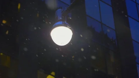 Snow falling around bright light lamp post in winter 09 Stock Footage 99066838