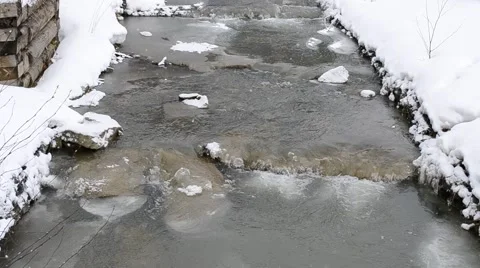 Snow falling beautifully on background of small mountain river Stock Footage 50086910