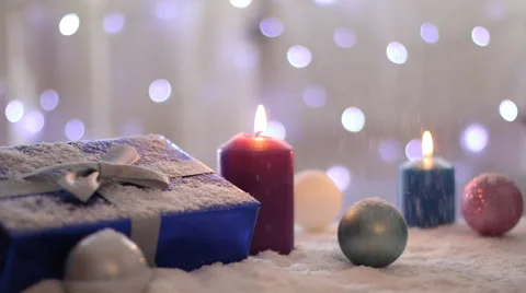 Snow falling on a Christmas present, ornaments twinkle Stock Footage 56280972