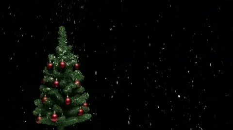 Snow falling on Christmas tree with red decorations Stock Footage