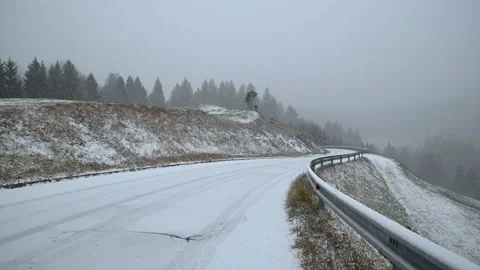 Snow falling on countryside mountain paved road in Slovenia Stock Footage 144424540
