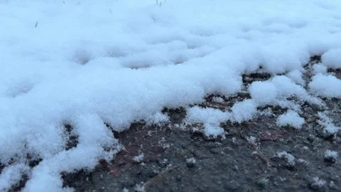 Snow falling on dirt track road surface on winter evening Stock Footage 328730347