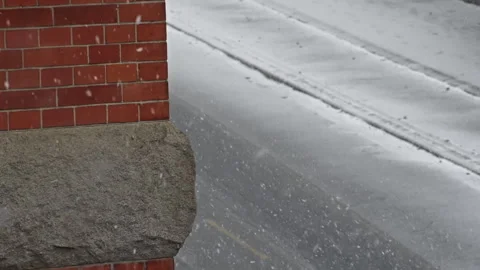 Snow falling down with a stonewall and road in the background Stock Footage 268619553