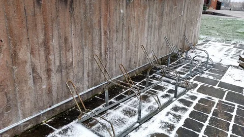 Snow Falling on Empty Bicycle Parking Stand Stock Footage 99647417