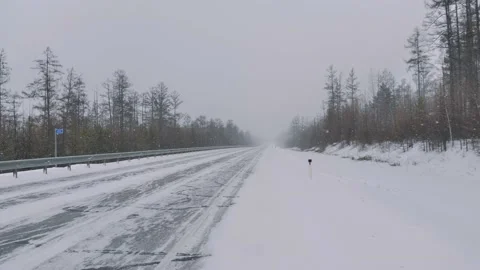 Snow falling on an empty intercity highway asphalt roadway. Winter season Video stock 166218515
