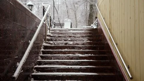Snow falling on empty staircase in urban setting Stock Photos