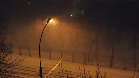 Snow falling heavily in the dim light of a streetlight on the frosty night. Stock Footage 102141605