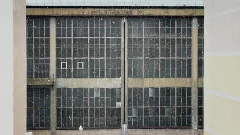 Snow falling before an industrial building with windows. Stock Footage 309207034