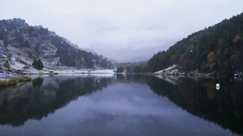 Snow falling at lake in the mountains Stock Footage 266681636