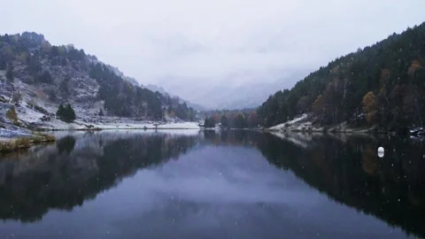 Snow falling at lake in the mountains Stock Footage 266682677