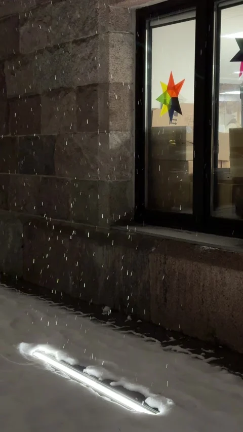 Snow falling in light of illumination with window at background. Vertical Stock Footage 258783473
