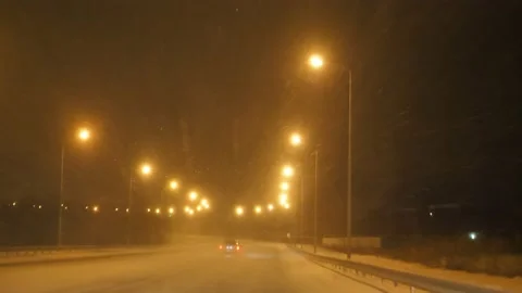 Snow falling at night on an empty road, no traffic. Stock Footage 220194541
