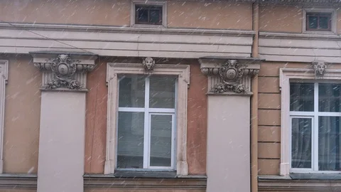 Snow falling outside the window on the background of a European house Stock Footage 124268396