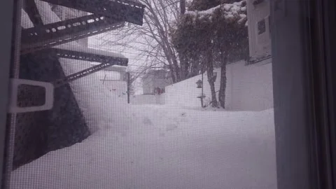 Snow falling outside window during winter snowstorm Stock Footage 326377982
