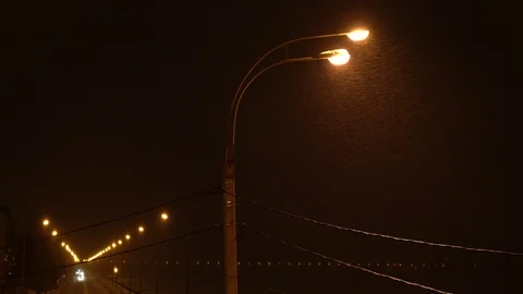 Snow is falling over warm light of street lamp. Winter city landscape Stock Footage 88078426