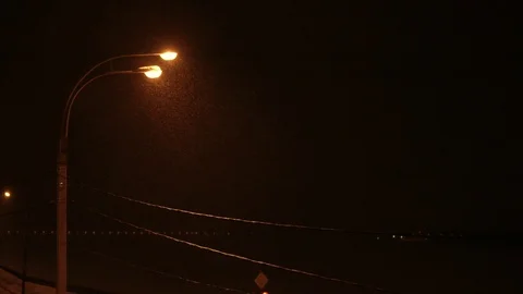 Snow is falling over warm light of street lamp. Slow motion Stock Footage 88078500