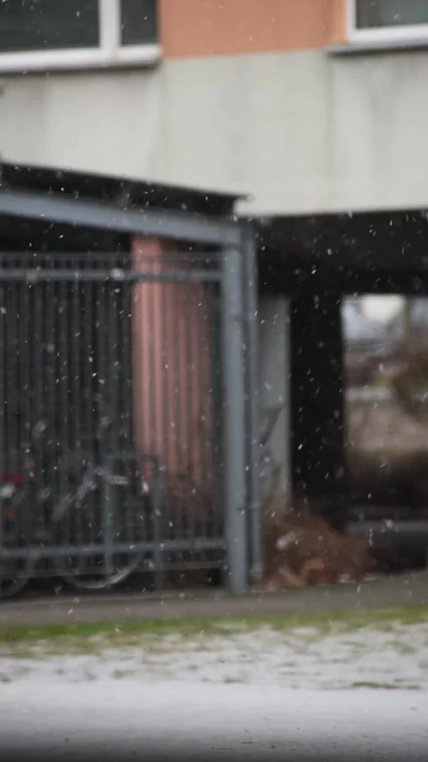 Snow Falling Past A Covered Bicycle Shelter And Facade Stock Footage 343447512