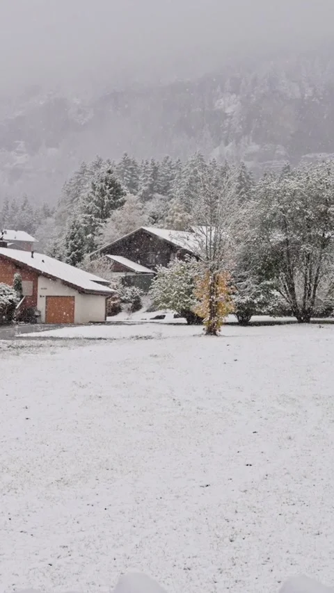 Snow falling. A picturesque view of a quaint, cozy wooden village beautifully Stock Footage 312476378