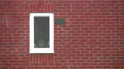 Snow falling on red brick background with white framed window Stock Footage 35055946