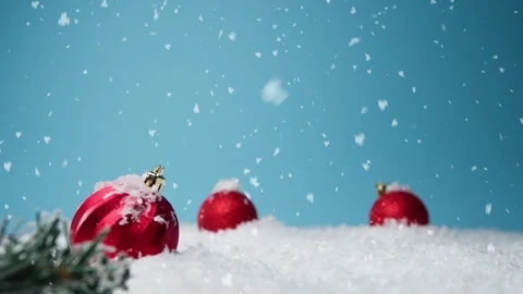 Snow falling on red Christmas decorations Stock Footage 256699044